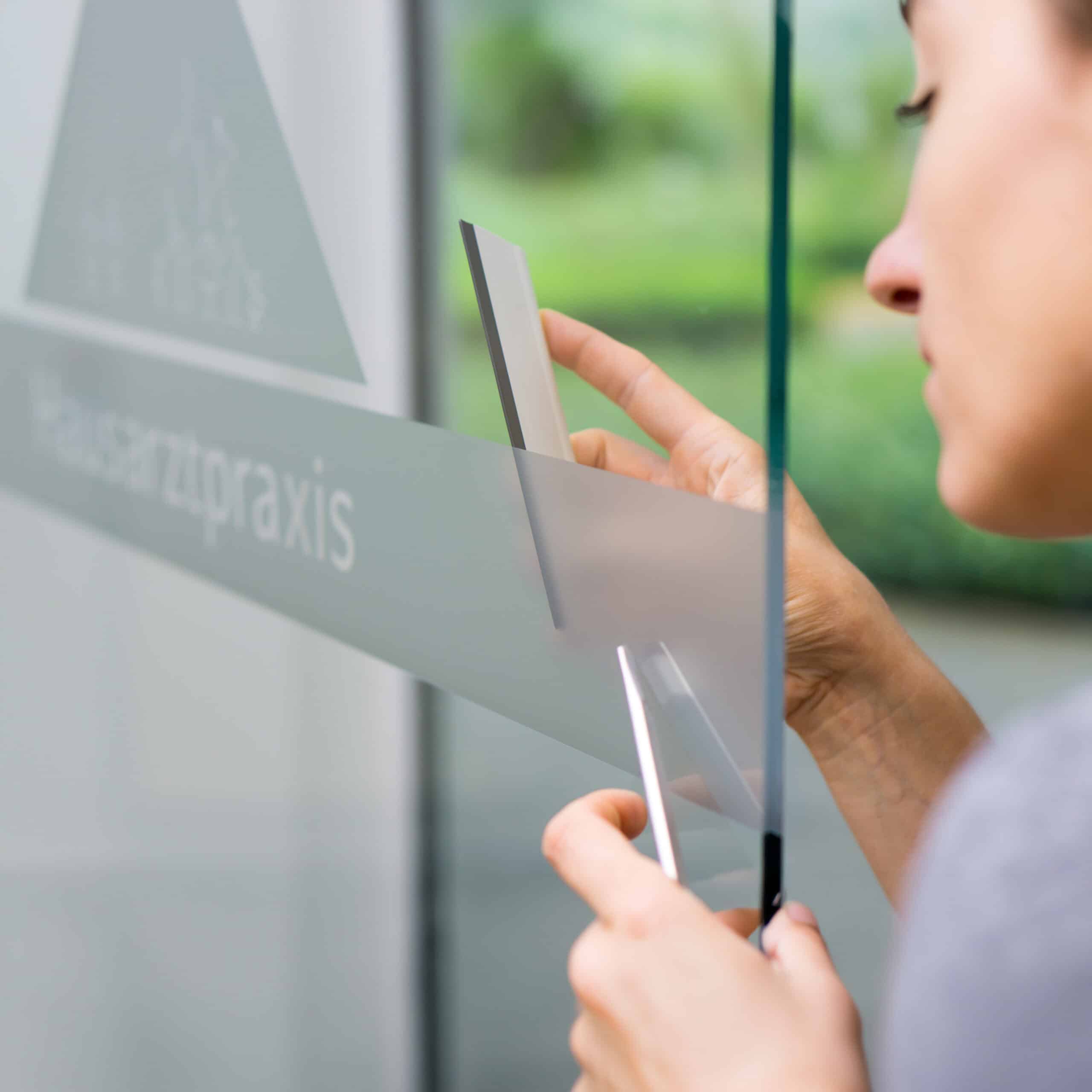 Professioneller Werbetechniker von sign point GmbH Braunschweig bei der fachgerechten Montage einer Folienbeschriftung